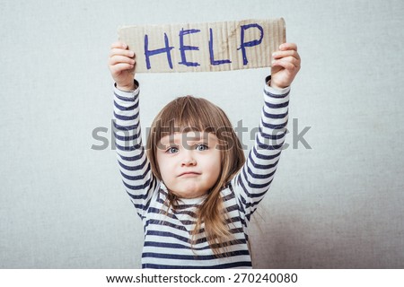 Conceptual image of a sad dejected little girl with a pouting lip standing holding a handwritten HELP sign