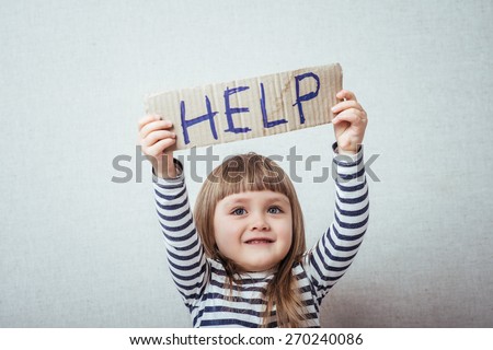 Conceptual image of a sad dejected little girl with a pouting lip standing holding a handwritten HELP sign