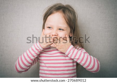 surprised little girl covered his mouth with his hands