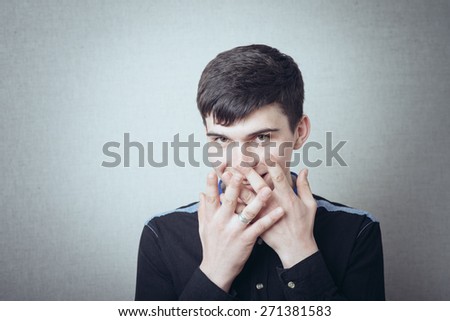 man covers his mouth with his hands and holding back laughter
