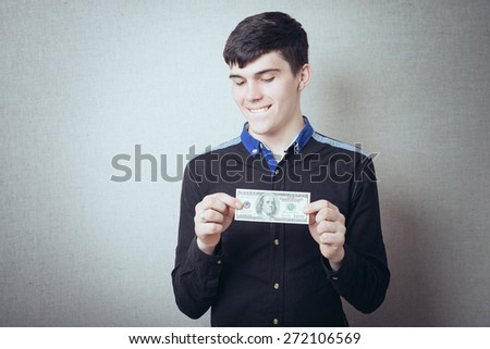 Portrait of smiling young man holding fanned US paper currency