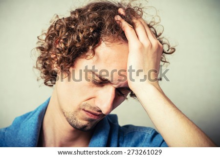 curly man made a mistake, and clings to his forehead hands