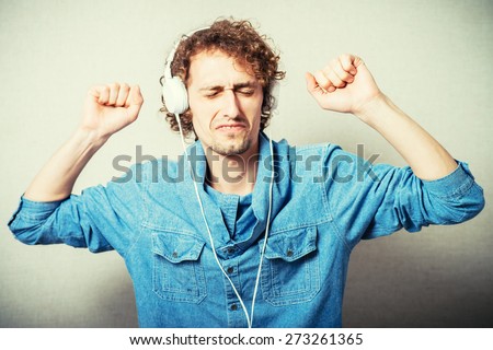 curly man listening to music on headphones white, dancing