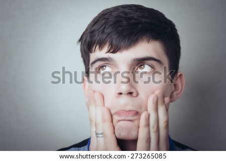 Man thinking about something, shock, surprise, bad teeth hurt, sadness, dreams, tired. On a gray background.