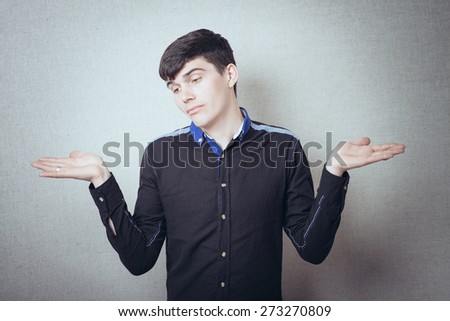 hands in different directions, gesture, empty, nothing, I know nothing, and here I am, a young handsome man on gray background