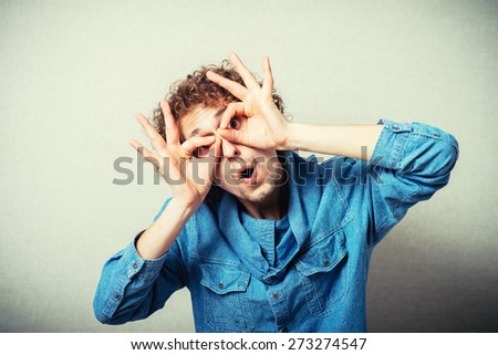 Funny man with hand over eyes, looking through fingers