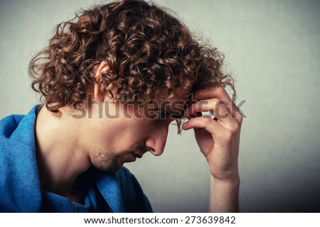 curly-haired man tries to think