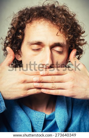 curly-haired man covers her mouth with her hands