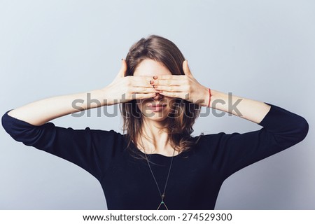 girl closes eyes with her hands