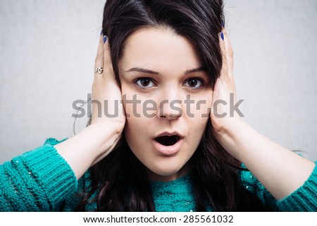 Young woman with  its hands covering his ears not to hear noise.