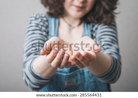 girl holding something in her hands, wearing a jumpsuit