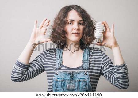 Woman holds in her hand new generation of light bulb