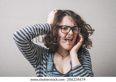 Woman angry cries on the phone. Gray background