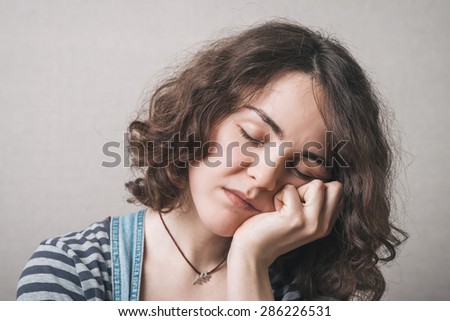 A woman wants to sleep. Gray background