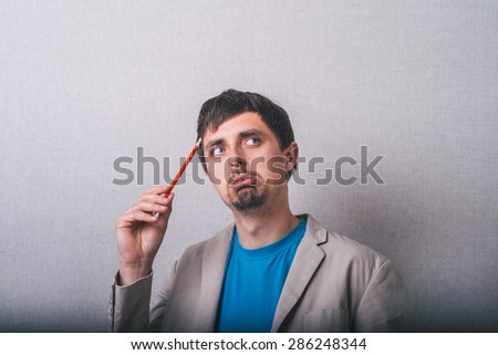 man thinking about something with pencil