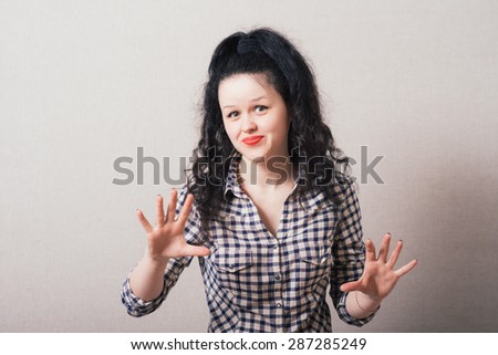 Closeup portrait of young annoyed woman with bad attitude, giving talk to hand gesture with palm outward. Negative human emotion, facial expression feeling, body language