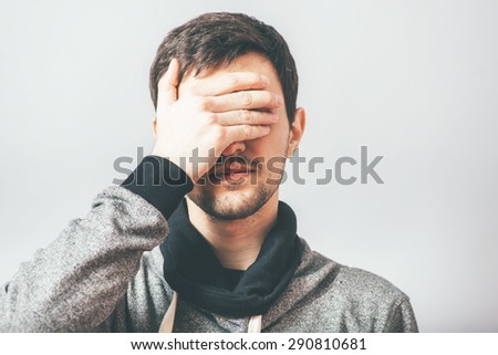 man closes his eyes with his hands