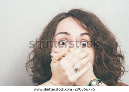 Girl scared and closes the mouth with her hands