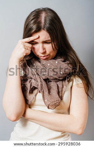 Young woman tired and wants to sleep on the hand. On a gray background.
