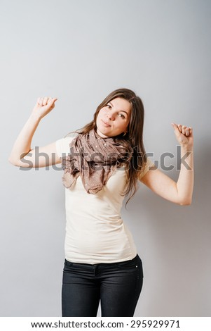 A young woman wants to sleep hands up. On a gray background.
