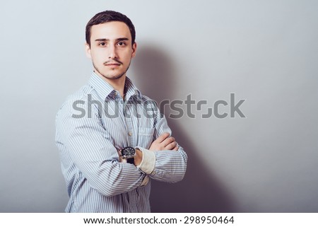 Serious young and attractive businessman  with his hands crossed on his chest