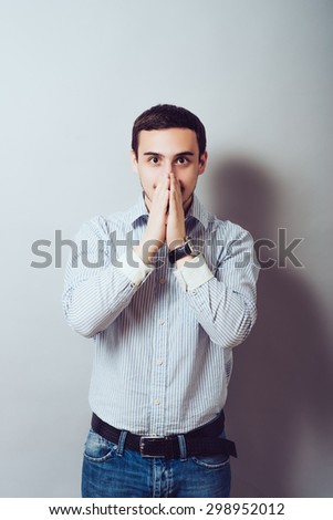 man covers his mouth with his hands so as not to laugh
