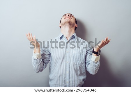 Closeup portrait of young man, praying looking up hoping for best asking for forgiveness, miracle isolated white background. Human emotions, facial expressions, feelings, reaction