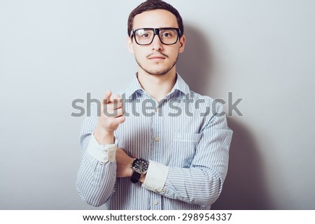 Young confident  guy smiling and pointing at camera