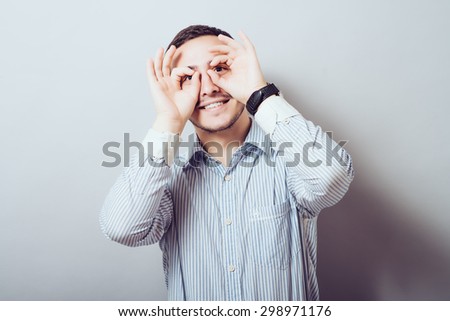 Concentrated businessman making binoculars with hands and looking through