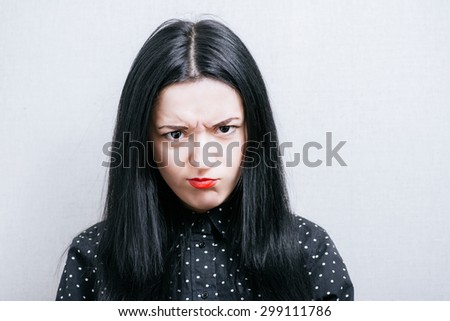 Woman doing offended person pouting. On a gray background.