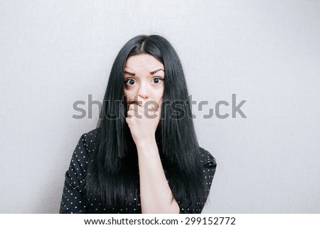 Beautiful Woman scared. On a gray background.