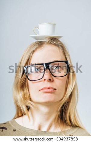 a girl holding a cup of coffee on head
