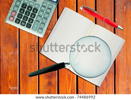 Magnifying glass and the working paper. (Business concept)
