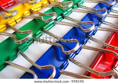 Colorful rows of large paper clips or binding clips.