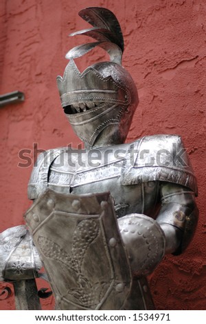 Suit of armor in front of stucco wall
