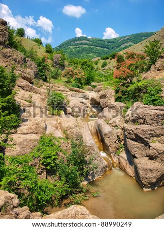 stream flowing over rocks in the background of the mountains. natural composition