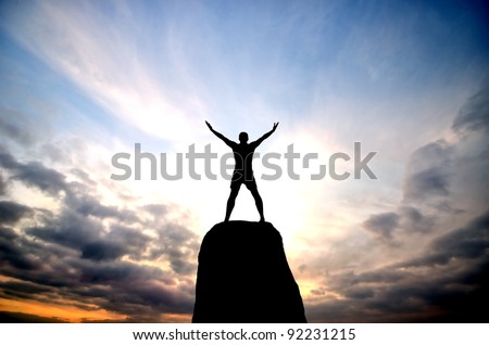 man on top of the mountain reaches for the sun