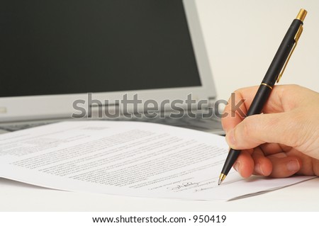 signing contract - signing a contract with laptop in background