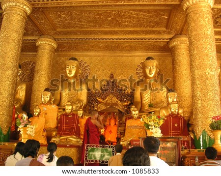 Monk and worshippers in Shwedagon Pagoda, Yangon, Myanmar