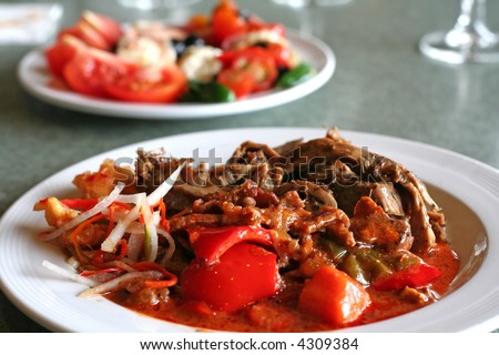 Plate of cooked meat and vegetables with gravy