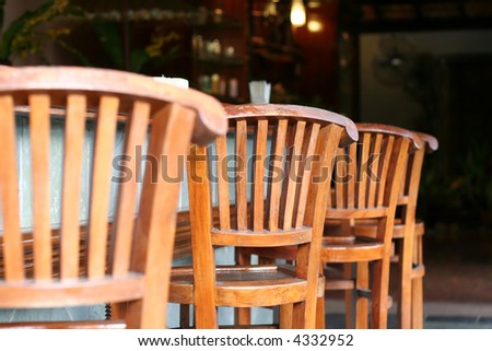 Row of wooden outdoor chairs in tropical style