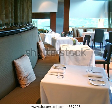 Tables set with plates and forks in a fancy restaurant