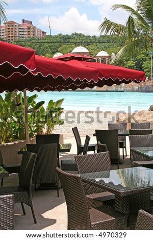 Tropical poolside outdoor cafe with umbrellas