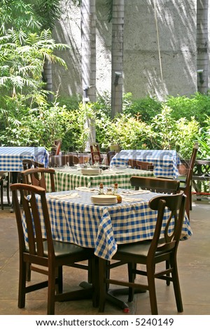 Outdoor italian restaurant with chairs and tables with checked tablecloths