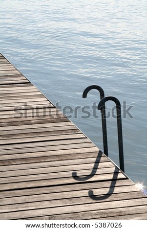 Wooden waterside walkway with ladder into the water