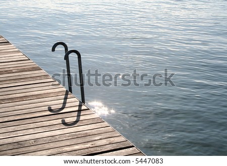 Wooden waterside walkway with ladder into the water