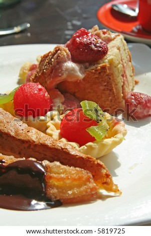 Dessert fruit cups and pastries on white plate