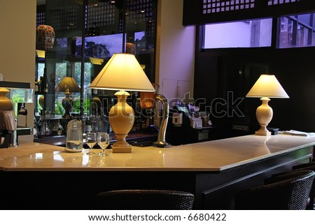 Elegant hotel bar counter with drinks on shelves