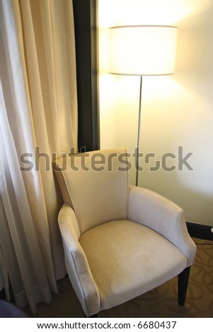 Single seat fabric sofa with lamp next to window