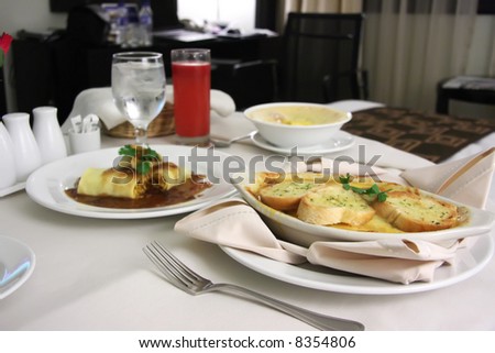 Room service food presentation with hotel bed in background